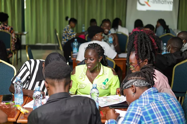 People from Q-intitiative in Kenya sitting around a table drawing. 