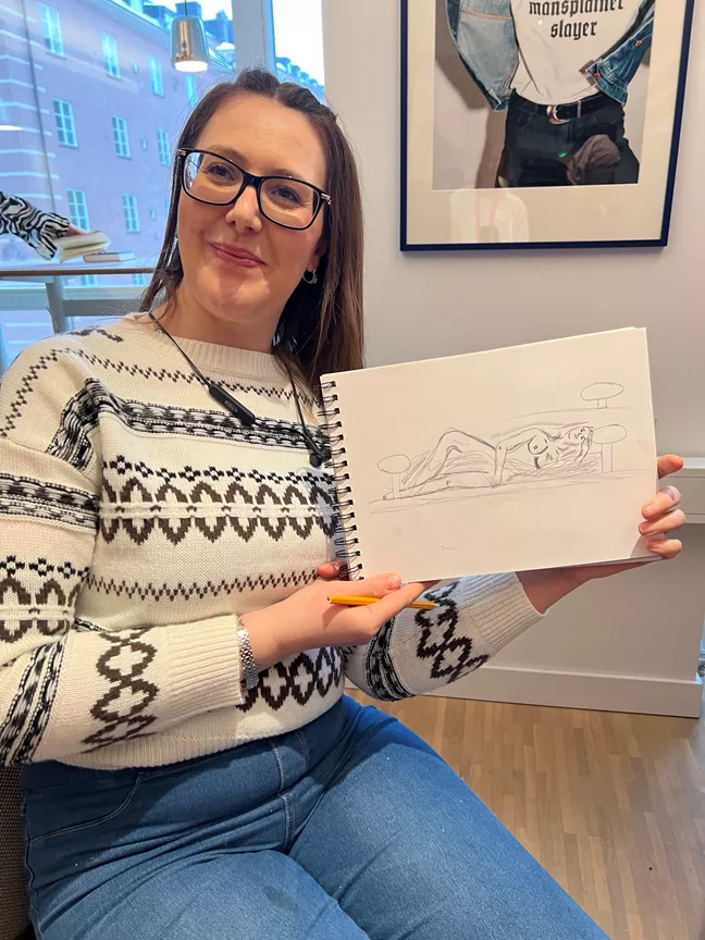 Sabrina håller upp sin krokiteckning. 